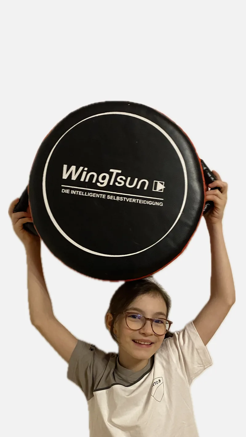 Mädchen hält stolz WingTsun-Pad hoch