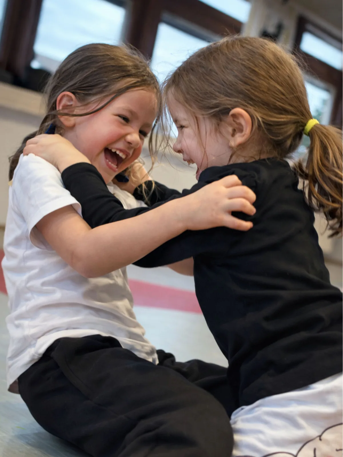 Zwei Mädchen lachen zusammen beim WingTsun Training