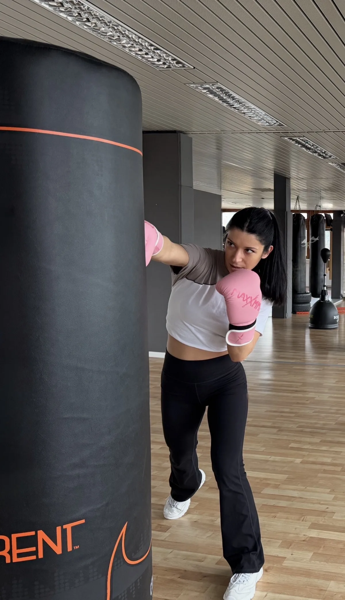 Frau trainiert am Boxsack beim Fitnessboxen